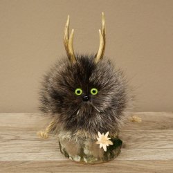 Wolpertinger «Wolpi», modelo mini, sobre base de madera, con flor de las nieves y ojos verdes. Altura: 22 cm. 86.1.3.53