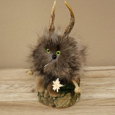 Wolpertinger «Wolpi», modelo mini, sobre base de madera, con flor de las nieves y ojos verdes. Altura: 23 cm. 86.1.3.56